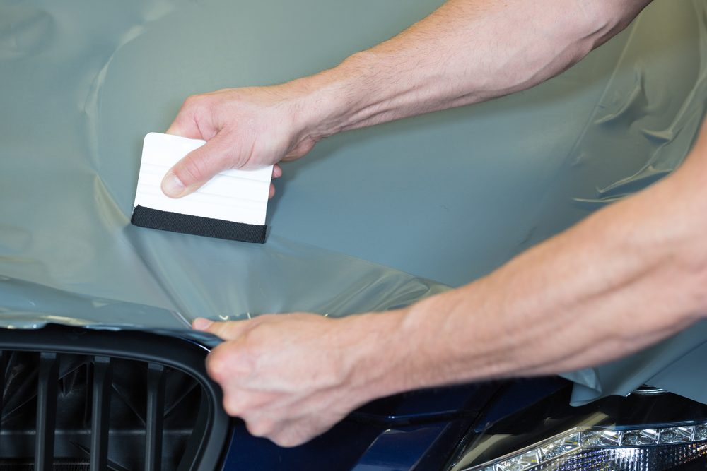 Protection film being worked down over wet paint with a squeegee