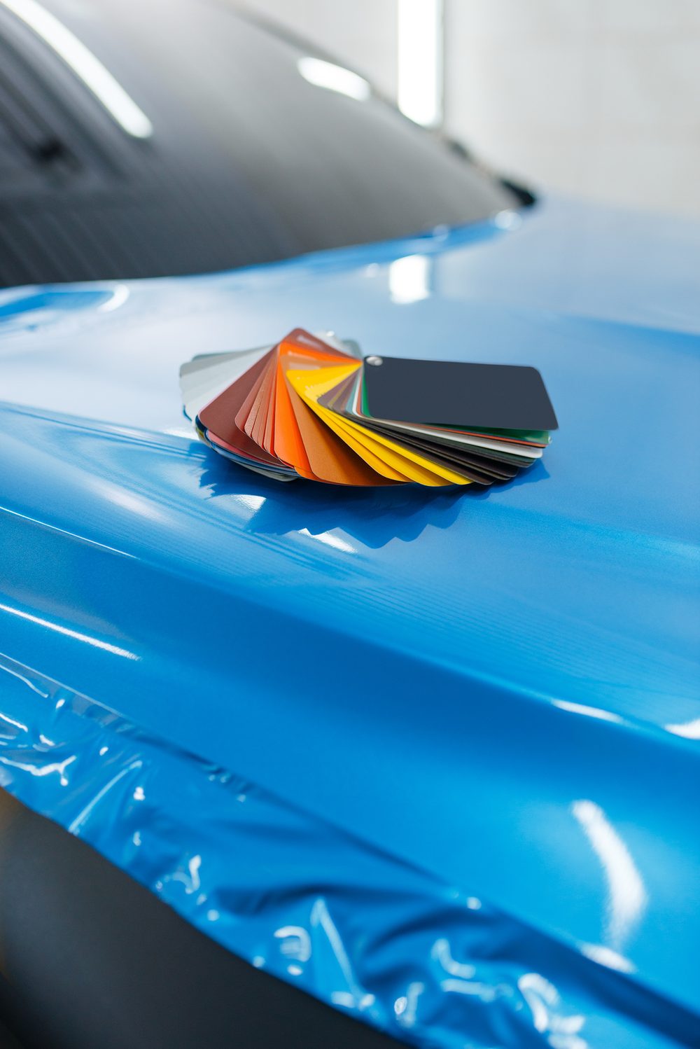 Blue vinyl laid over a hood, swatch fan on top